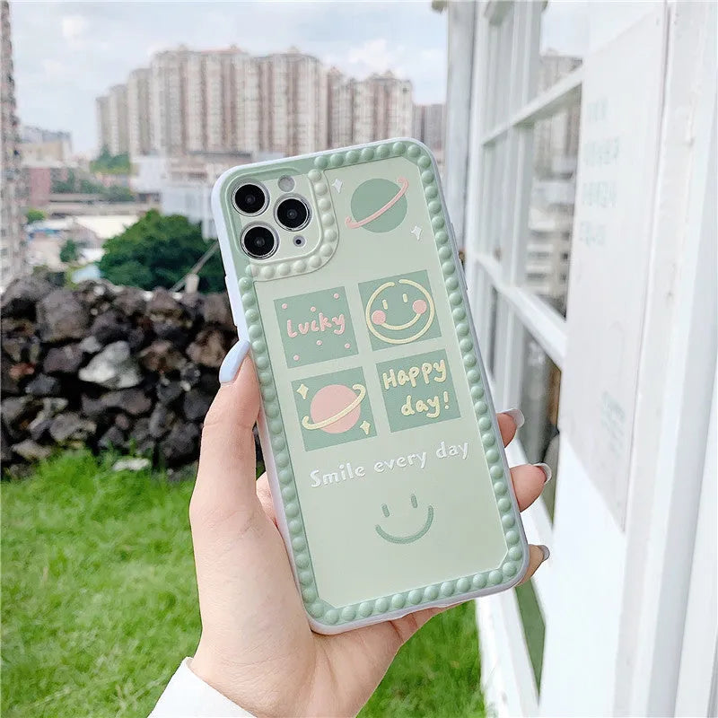 Green TPU iPhone case with geometric pattern and smiley faces in a polka dot frame for multiple models.