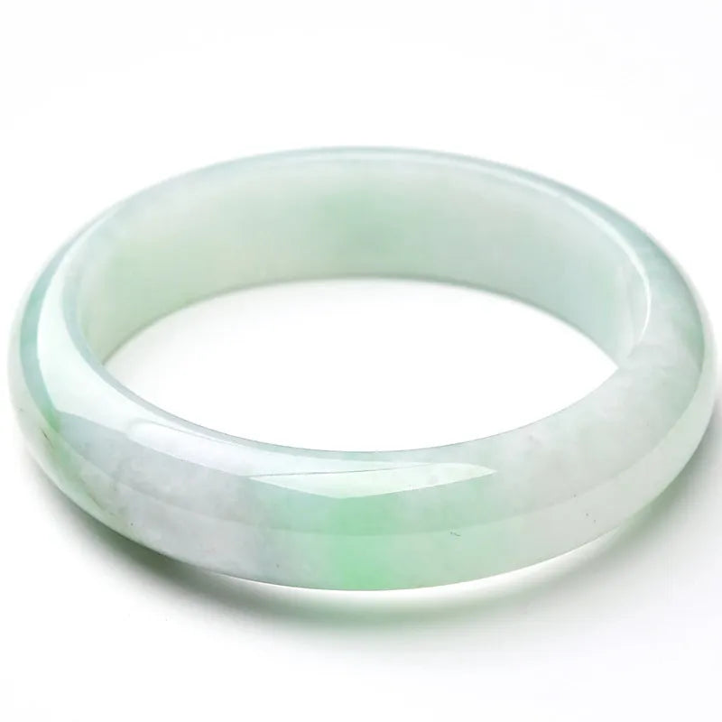 A light green jade bracelet for men and women, shown on a wrist, with a natural stone texture.