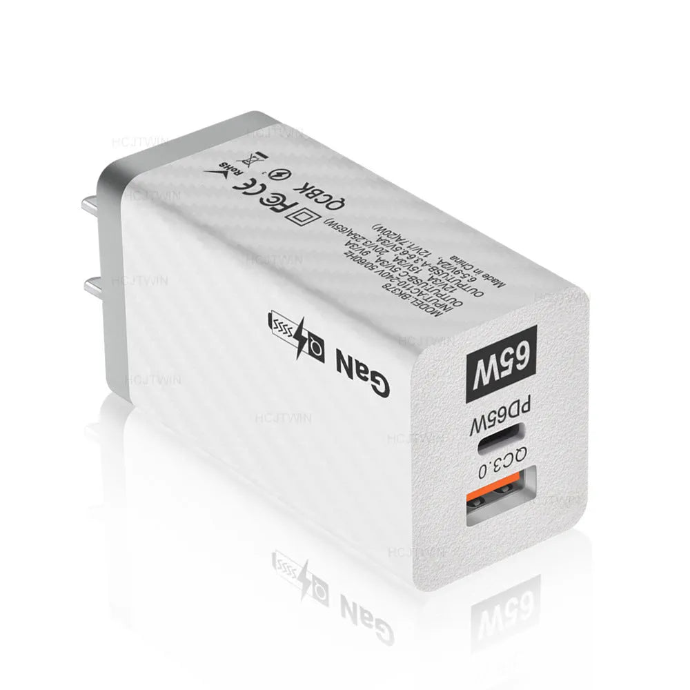 Compact white 65W Gallium Nitride laptop charger with USB-C port next to EU and US plug options.