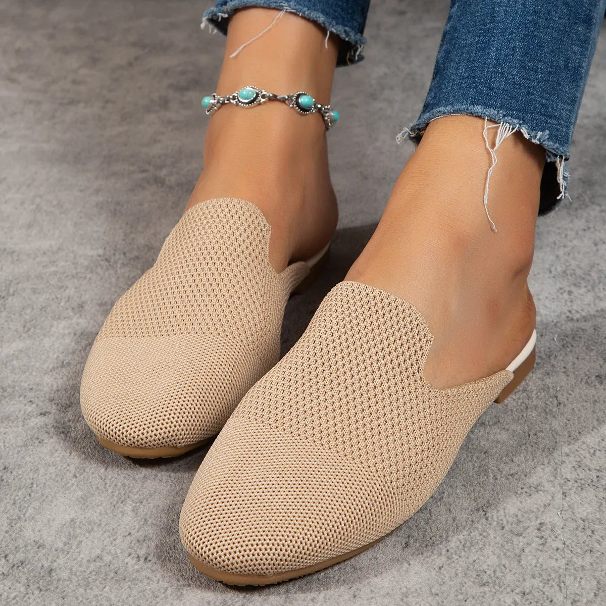 A pair of apricot-coloured mesh slip-on sandals with a cloth upper and flat rubber sole.