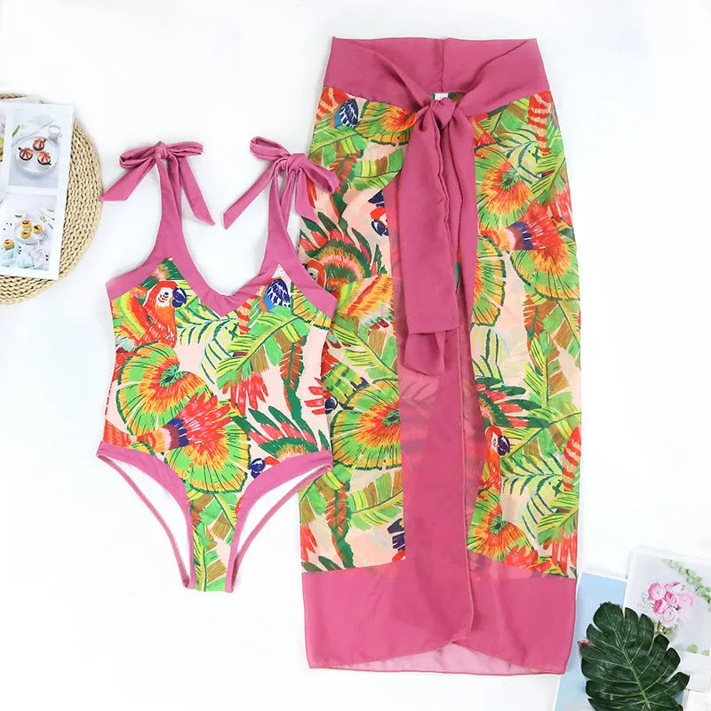 Pink floral print one-piece swimsuit with V-neck, covered belly, and an attached skirt.
