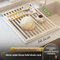 Milky white foldable stainless steel kitchen draining rack shown next to a sink.