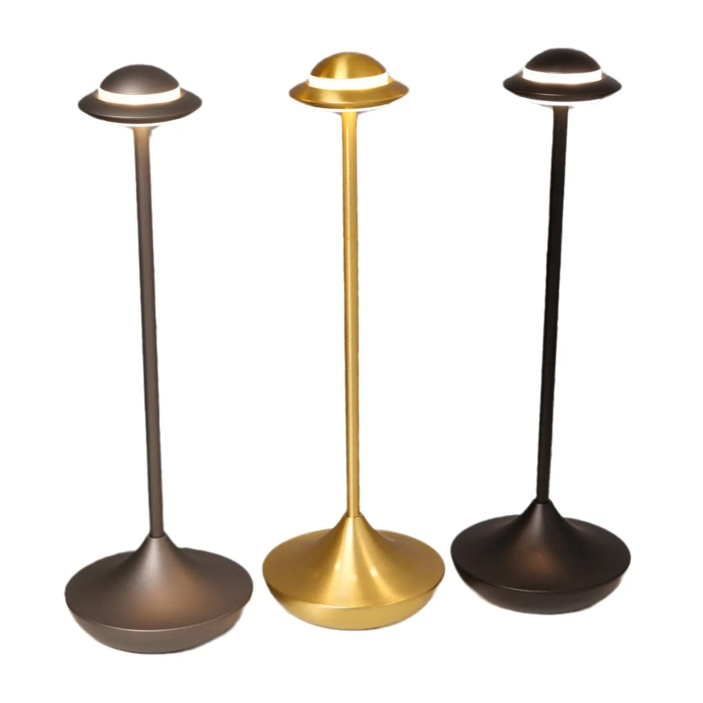 Gold UFO-shaped metal table lamp with touch dimming controls on a desk.