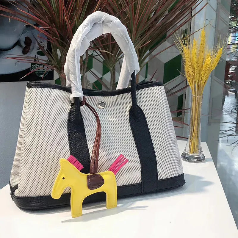 Women's canvas crossbody shoulder tote bag with leather detailing and bucket shape