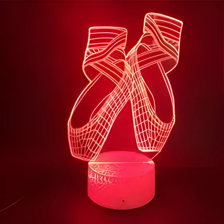 3D acrylic ballet shoe night light with colourful LED illumination on ABS base, remote control beside it