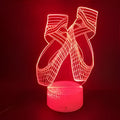 3D acrylic ballet shoe night light with colourful LED illumination on ABS base, remote control beside it