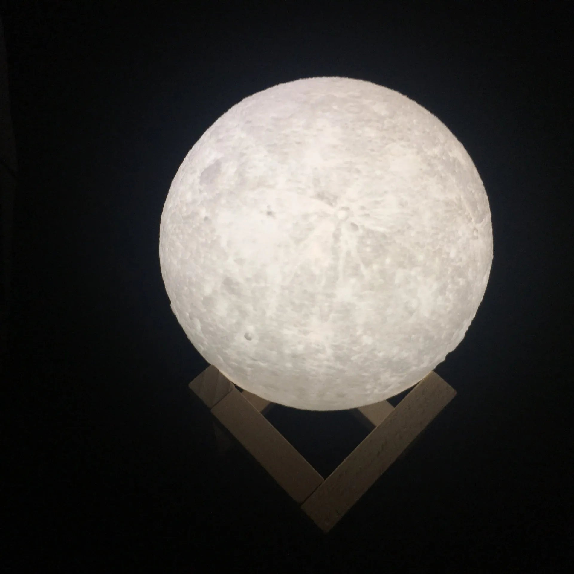 3D printed white moon lamp on wooden stand with colour-changing LED light