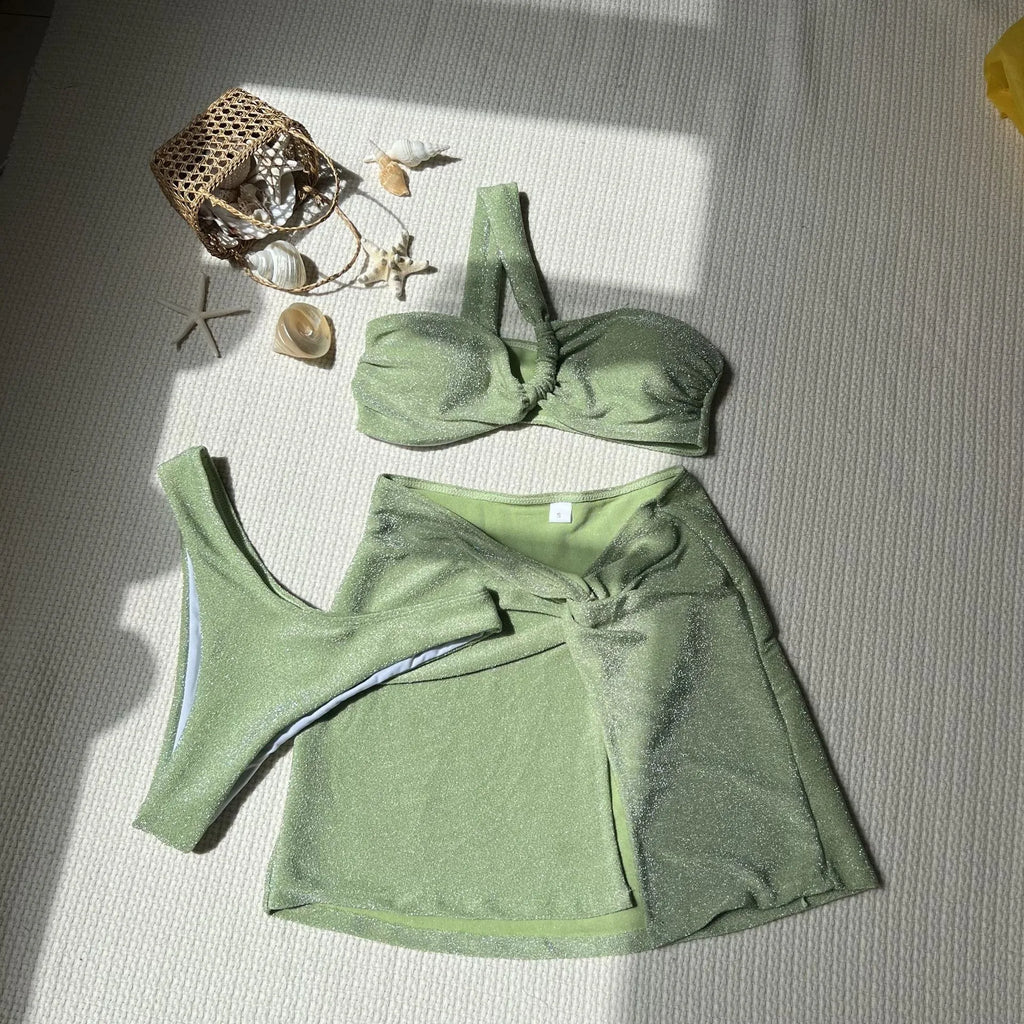Light green one-shoulder tube top three-piece swimsuit set with matching skirt.