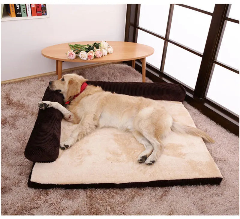 Grey corduroy dog sofa bed with raised sides on a wooden floor, showing its non-slip base.