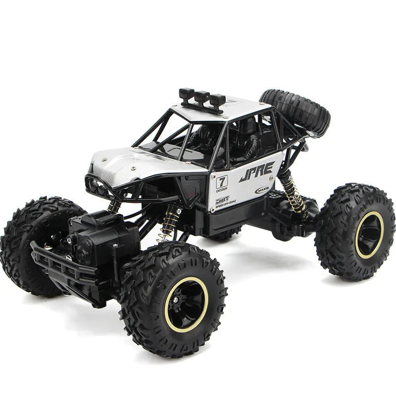 Large black or silver 4WD remote control climbing car on off-road terrain with wireless remote.