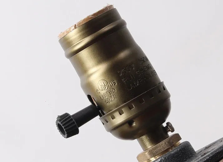 Industrial-style wooden and iron water pipe table lamp on a surface, showing its compact size.