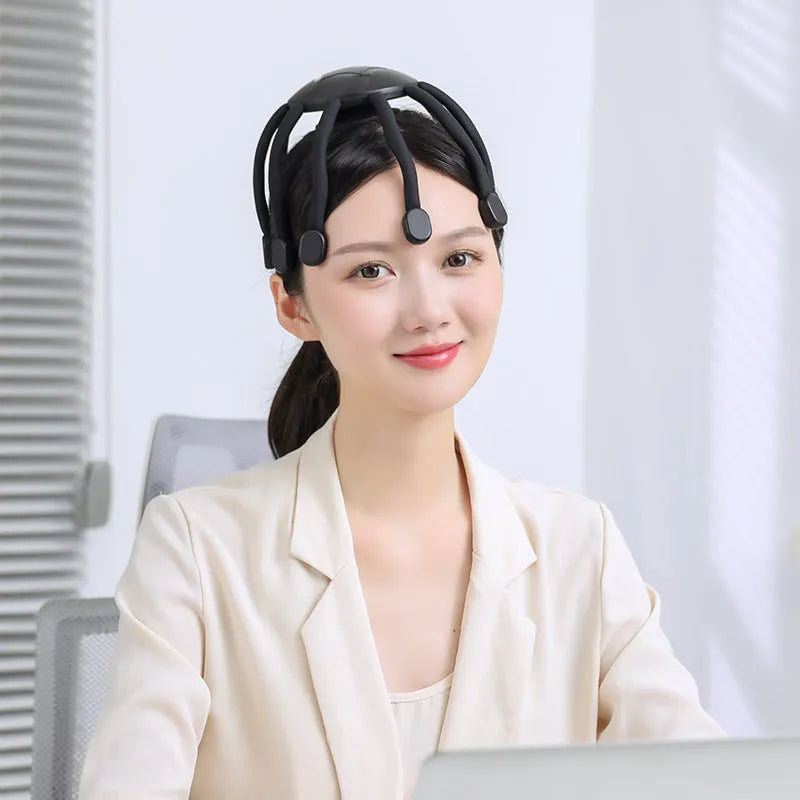 Black head massager with multiple vibrating claws on a scalp, showing four speed mode buttons and USB charging port