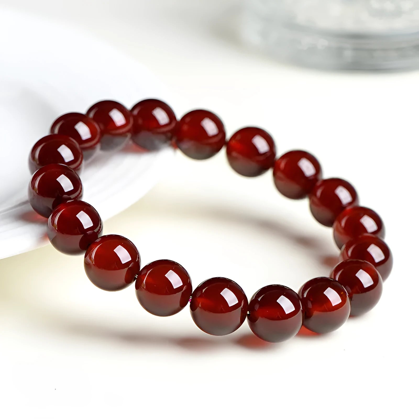 Natural orange red garnet ball bracelet with crystal beads showing ruyi pattern detailing