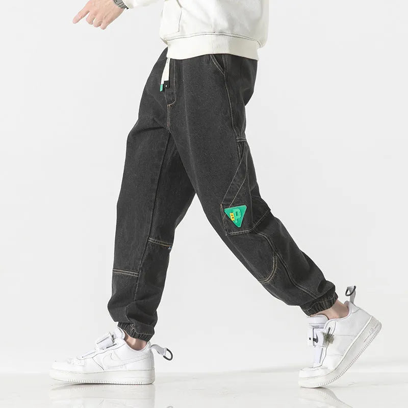 Men's loose-fit tapered cotton trousers in black colour showing mid-rise waist and tapered leg silhouette