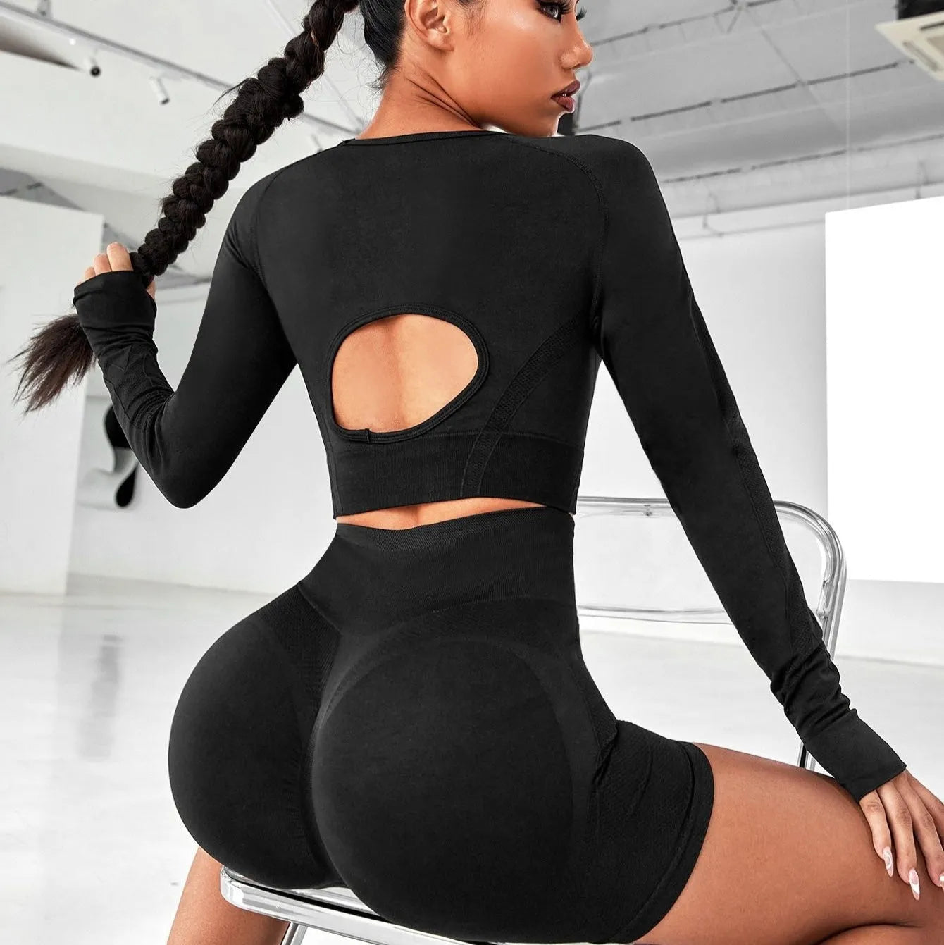 Women's black yoga suit with high waist hip lift design and long sleeves for fitness activities