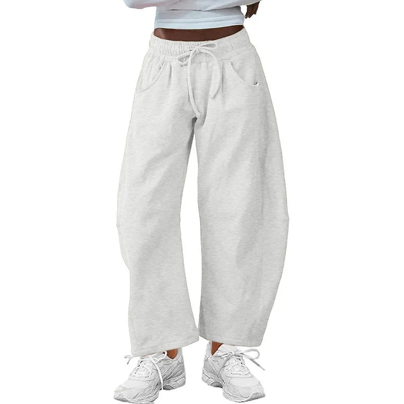Women's loose grey cropped sweatpants with drawstring waist and side pockets on a hanger.