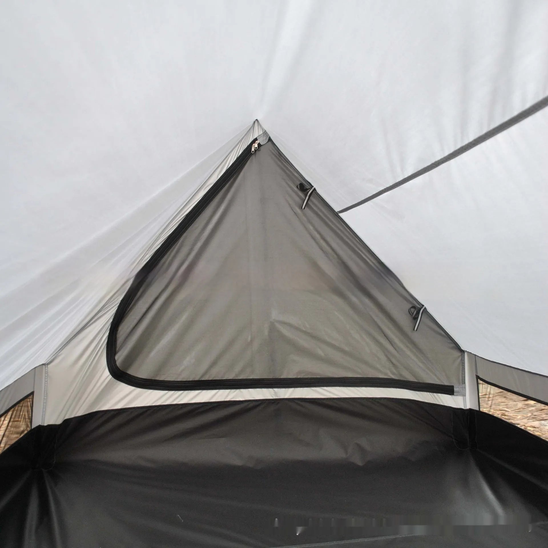 Brown or white A-line hiking tent without poles, supported by hiking canes