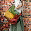 Cowhide leather crossbody travel bag showing stitching detail and capacity for 15-inch laptop