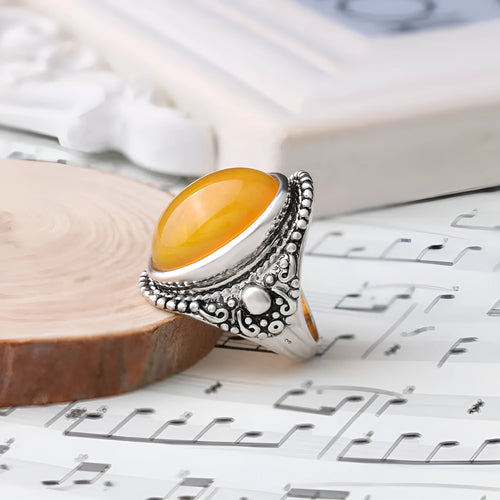 Close-up of a geometric retro ring in antique silver amber with a beeswax fluorescent finish.