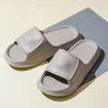 Pair of thick-soled EVA flip flop slippers in purple, showing deep sole profile.