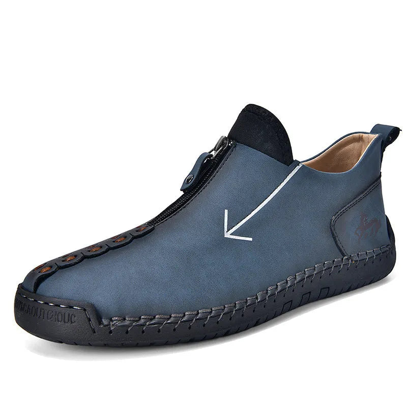 Men's black leather boots with a front zipper and round toe, showing hand-stitched sole detail.