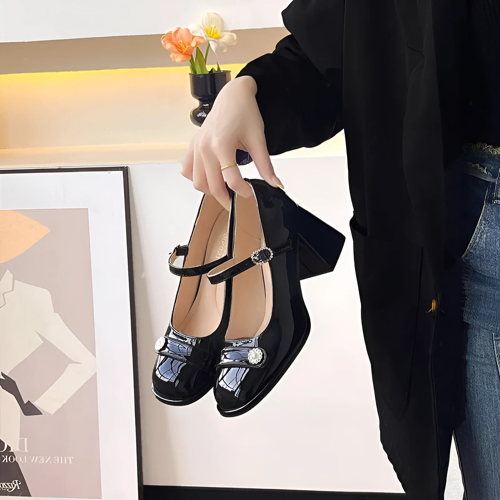 Women's black patent leather round toe shoes with a chunky heel and buckle fastening, shown in a widened fit style.