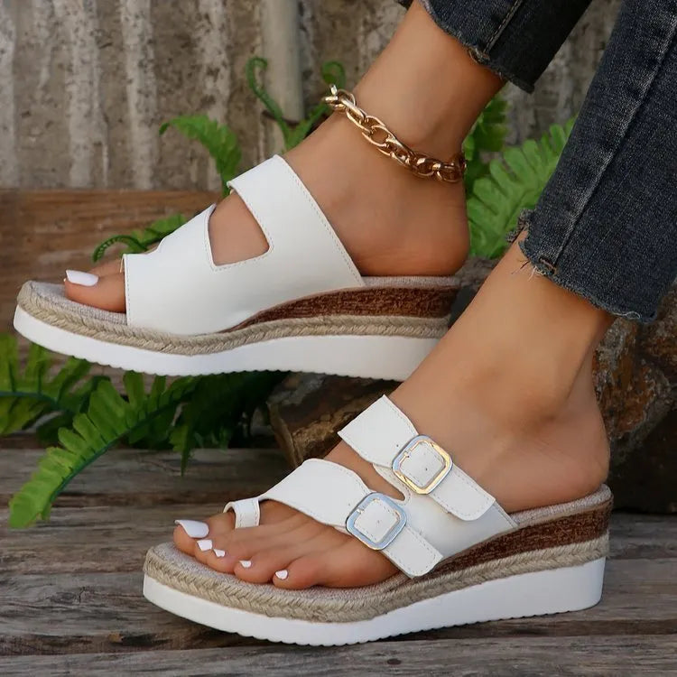 White women's wedge sandals with woven patent leather upper, peep toe, and finger-fit design on a rubber sole.