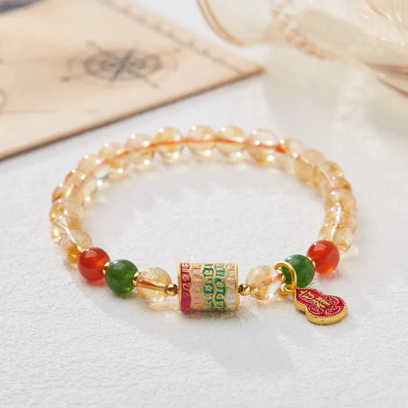 Close-up of a hand-woven citrine five sutra bracelet with 6mm geometric beads on a wrist.
