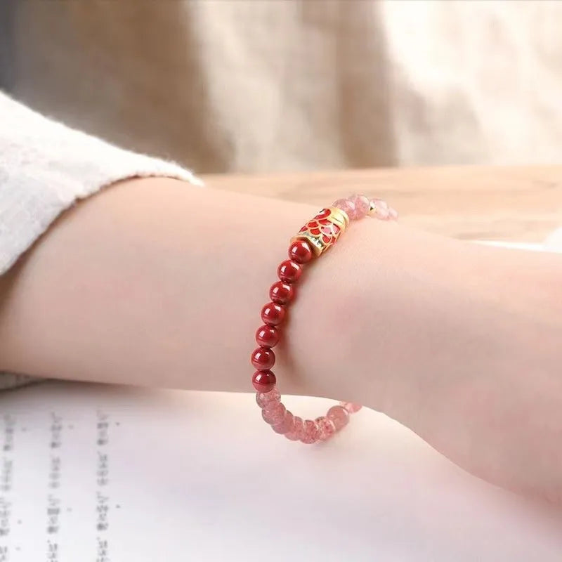Close-up of a women's purple cinnabar and strawberry quartz lucky bead bracelet in a retro style.