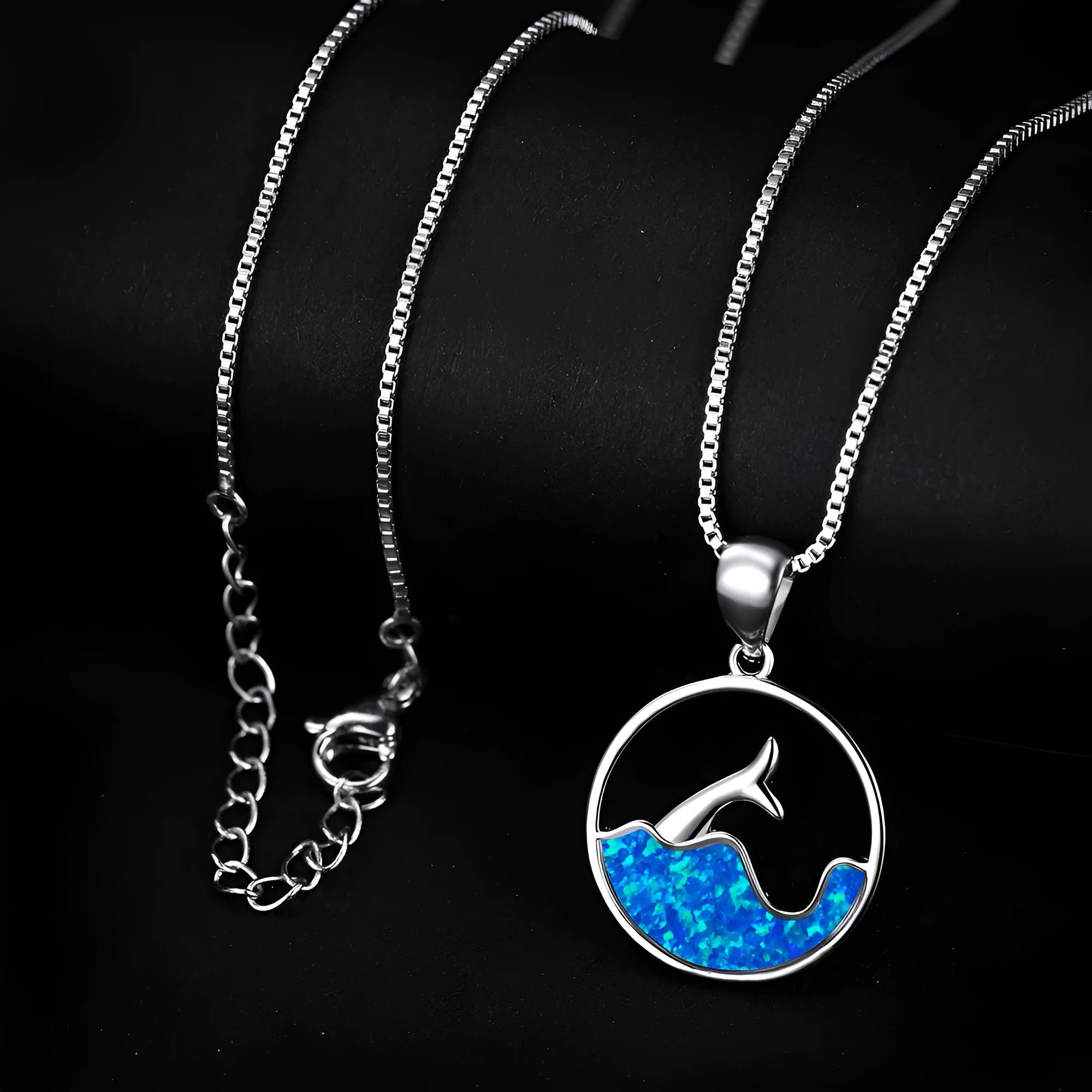 Geometric sea fishtail pendant necklace with a round blue opal stone on a thin chain.