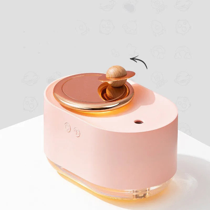 Green rotating planet-shaped USB humidifier with night light on a wooden desk.