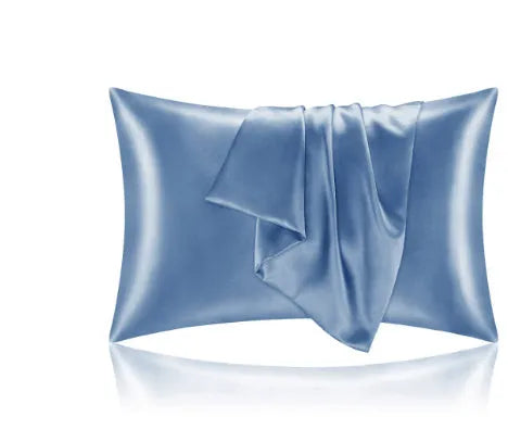 Dark blue polyester satin pillowcase with envelope closure on a bed with white sheets