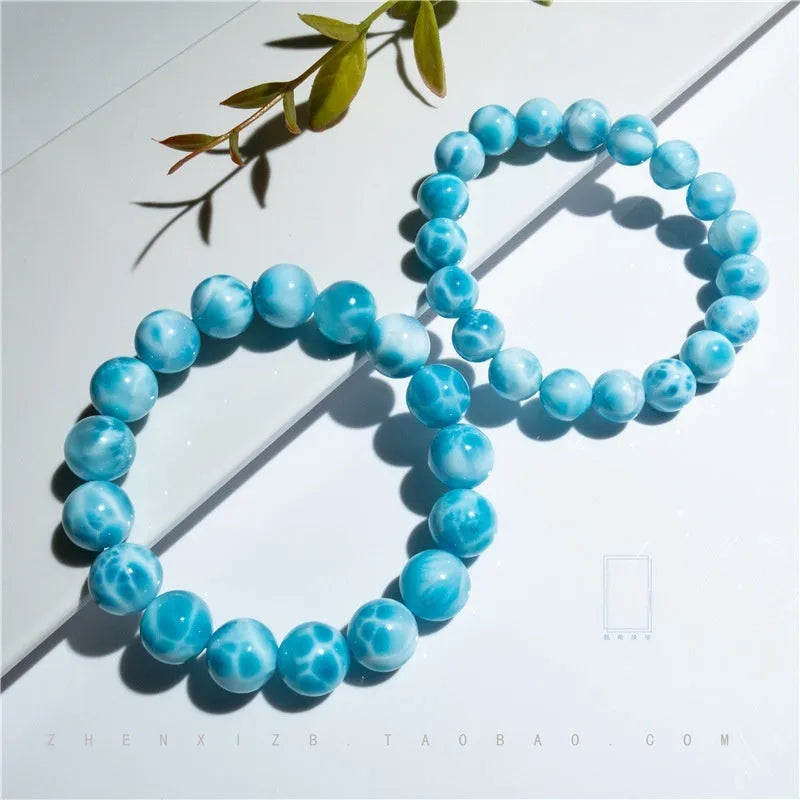 Blue handmade bodhi and pearl bracelet in Maillard style on a neutral background.