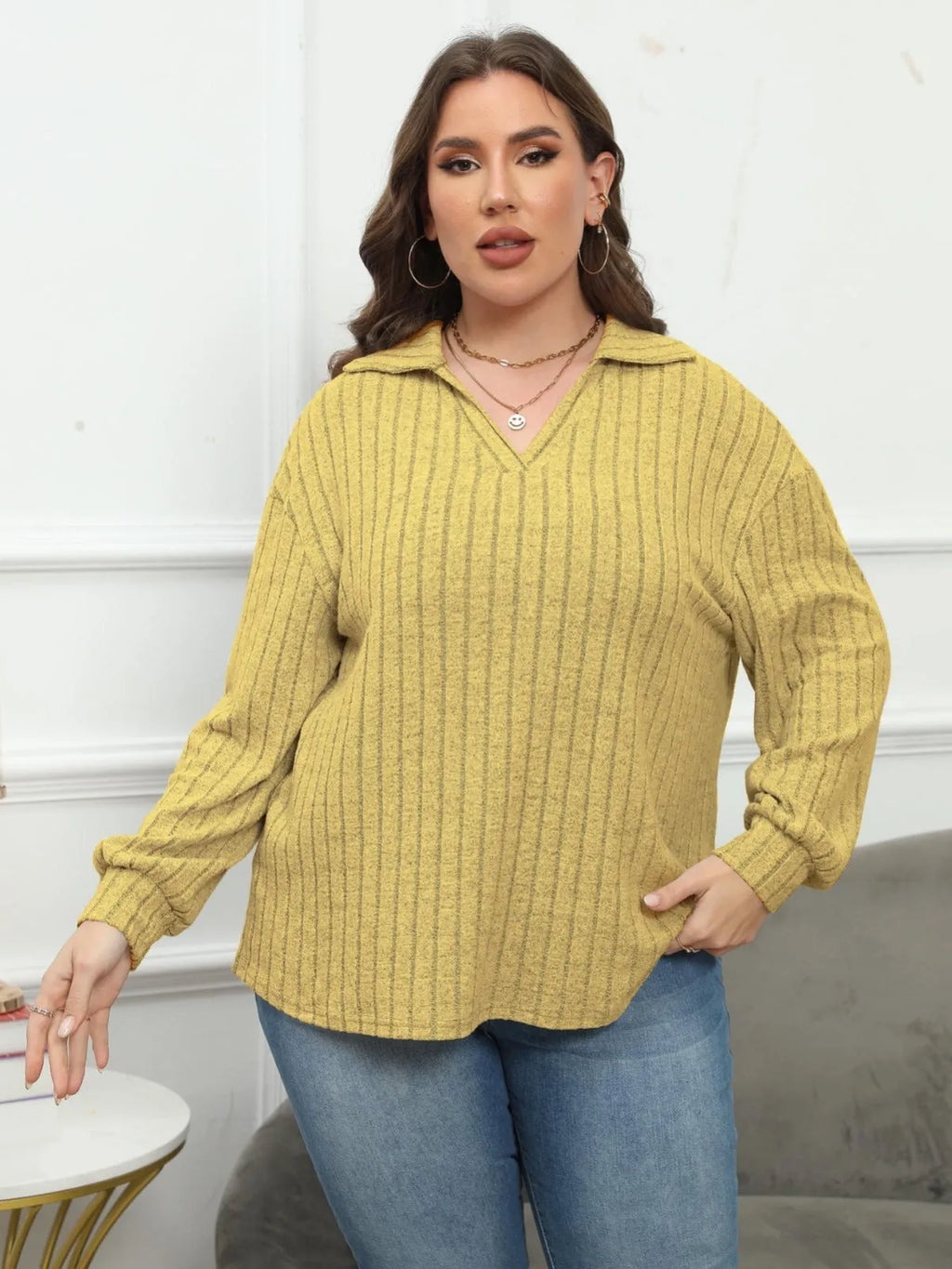 Plus size woman wearing a grey polo collar fleece pullover blouse with lantern sleeves.