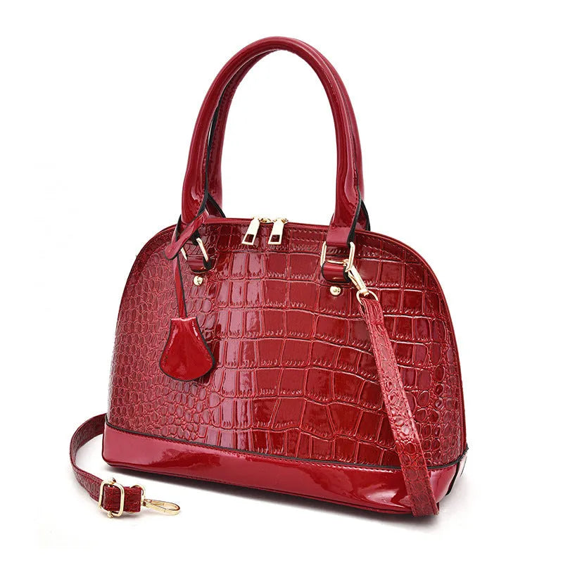 Large shiny black PU shoulder bag with crossbody strap showing interior polyester lining