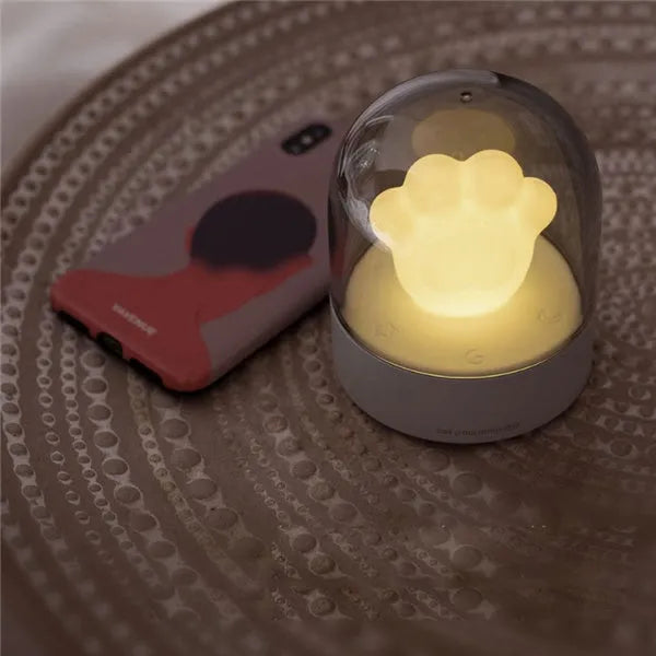 Grey or pink cat paw shaped USB rechargeable night light with musical functions on wooden desktop
