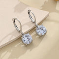 Silver-toned cubic zirconia stud earrings with 4mm round stone in claw setting on white background