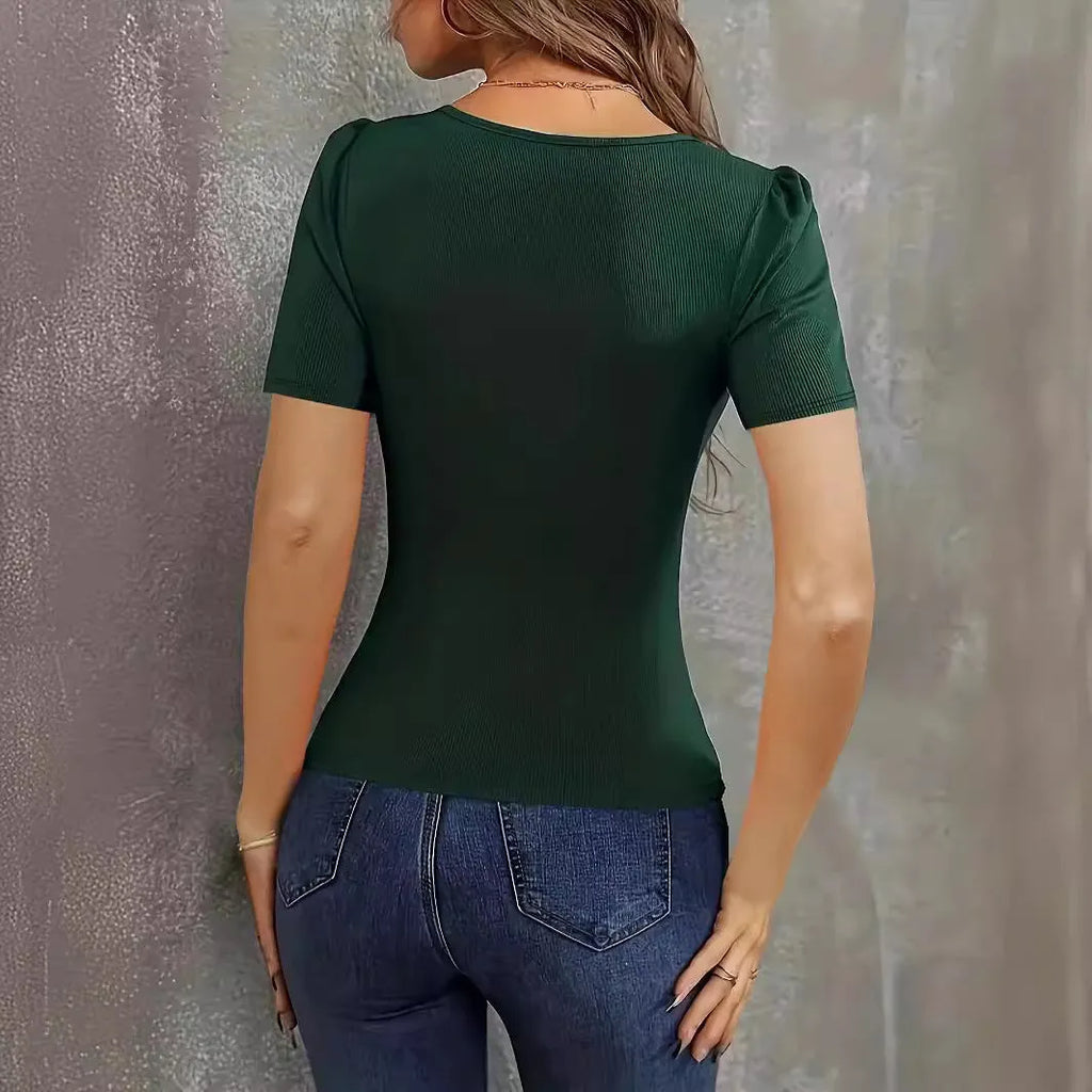 Woman wearing a wine red slim fit knitted short sleeve top with a low neckline.