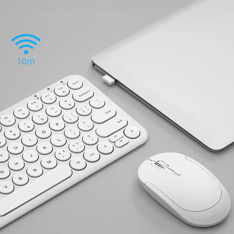 Ultra-thin white wireless keyboard and mouse set with USB receiver on a wooden desk.