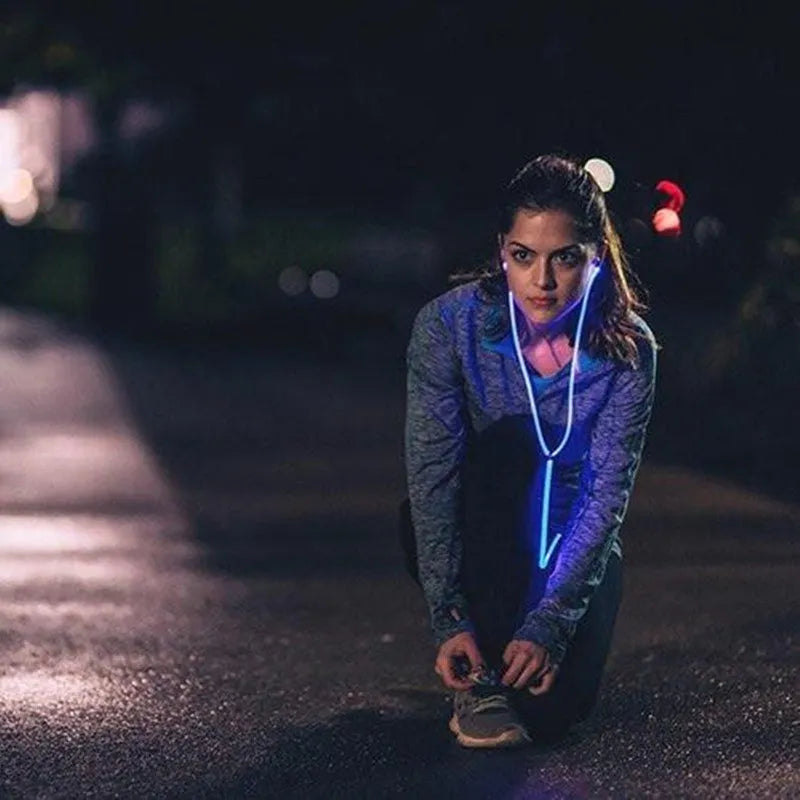 Blue wired earphones with glowing LED light lines on earpieces, showing 3.5mm plug and inline remote.
