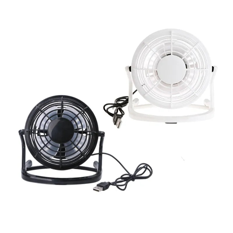 Compact black mini USB desk fan with adjustable tilt, placed next to a laptop.