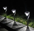 White solar-powered garden spotlight with adjustable head and solar panel on a stake for outdoor installation.