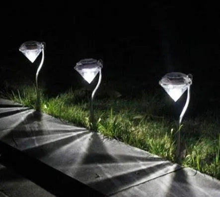 White solar-powered garden spotlight with adjustable head and solar panel on a stake for outdoor installation.