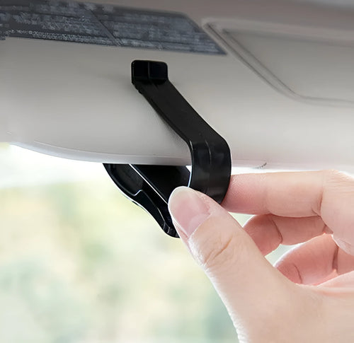 Black plastic multifunctional clip for mounting on a car sunshade to hold glasses, tickets, and ID cards.