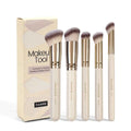 Apricot coloured angled makeup blush brush and four other synthetic brushes from a 5-piece set.