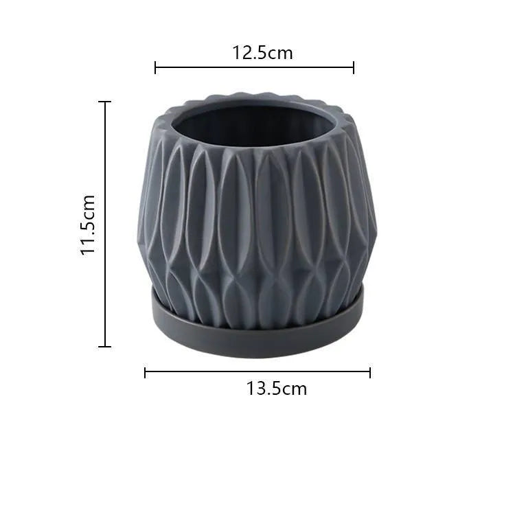 Grey small ceramic tabletop plant flowerpot on desktop with green plant