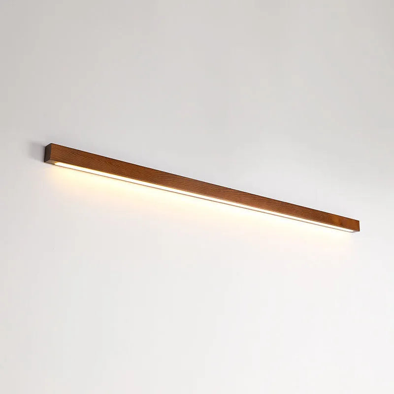 Walnut coloured linear wood and acrylic LED strip wall lamp mounted on a wall.