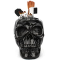 Skull head resin storage tube in black, 11x15x11cm, with open top showing inner 7cm diameter for storing beauty tools