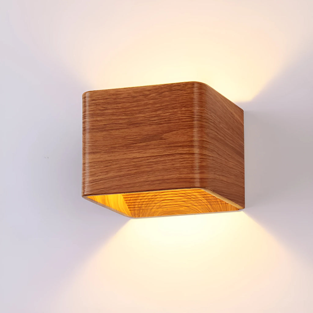 Square LED indoor wall lamp in black die-cast aluminium with warm white light on a wall