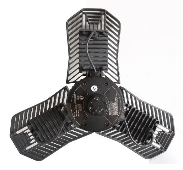 A foldable industrial LED garage flood light with a die-cast aluminum body, shown in a workshop setting.